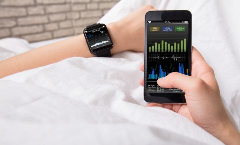 Woman's Hand Showing Heart Rate On Smart Watch And Cell Phone